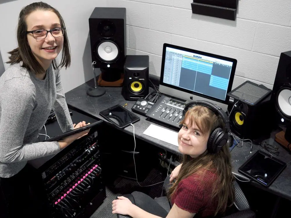 Two young women working together in a music recording studio during a co-op placement.