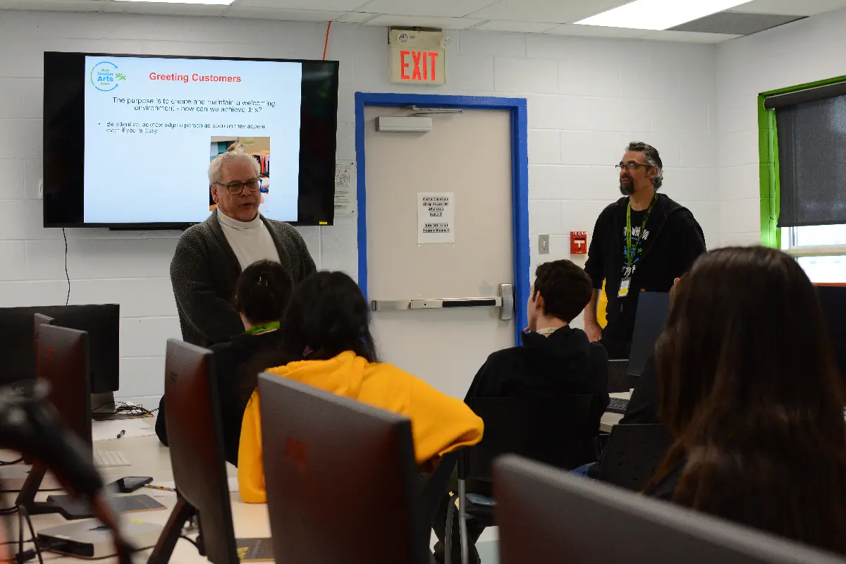 Instructor leads SHSM hands-on workshop, students at computers.